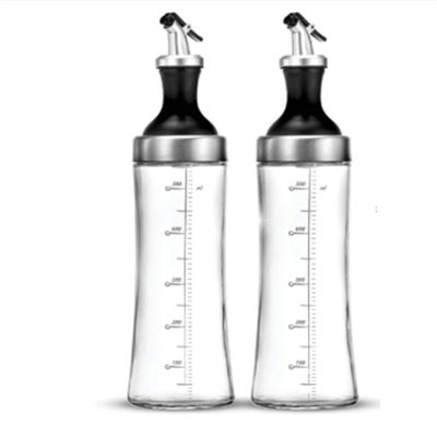 Un récipient en verre à haute teneur en borosilicate pour le ménage avec un tuyau incurvé et un régulateur de mesure de l'huile est stocké